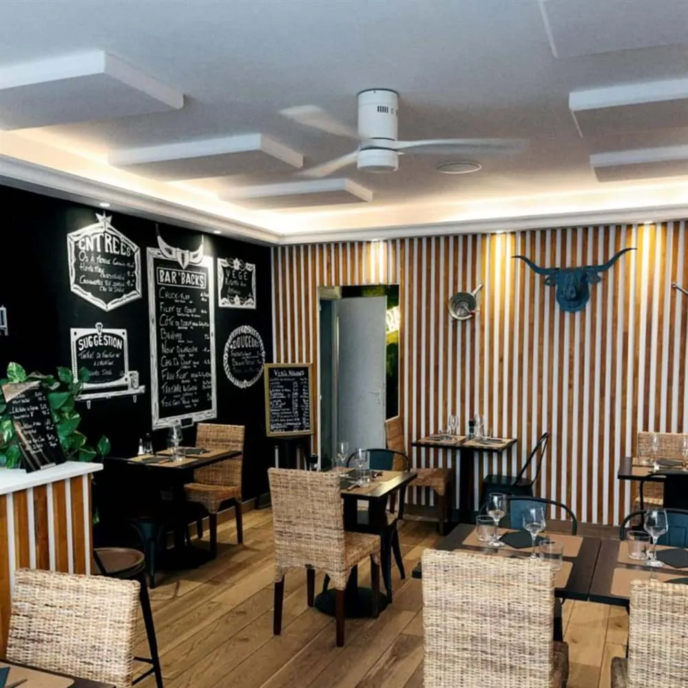 La salle du Bar'Back Évian : ardoises noires, bois et chaises en osier